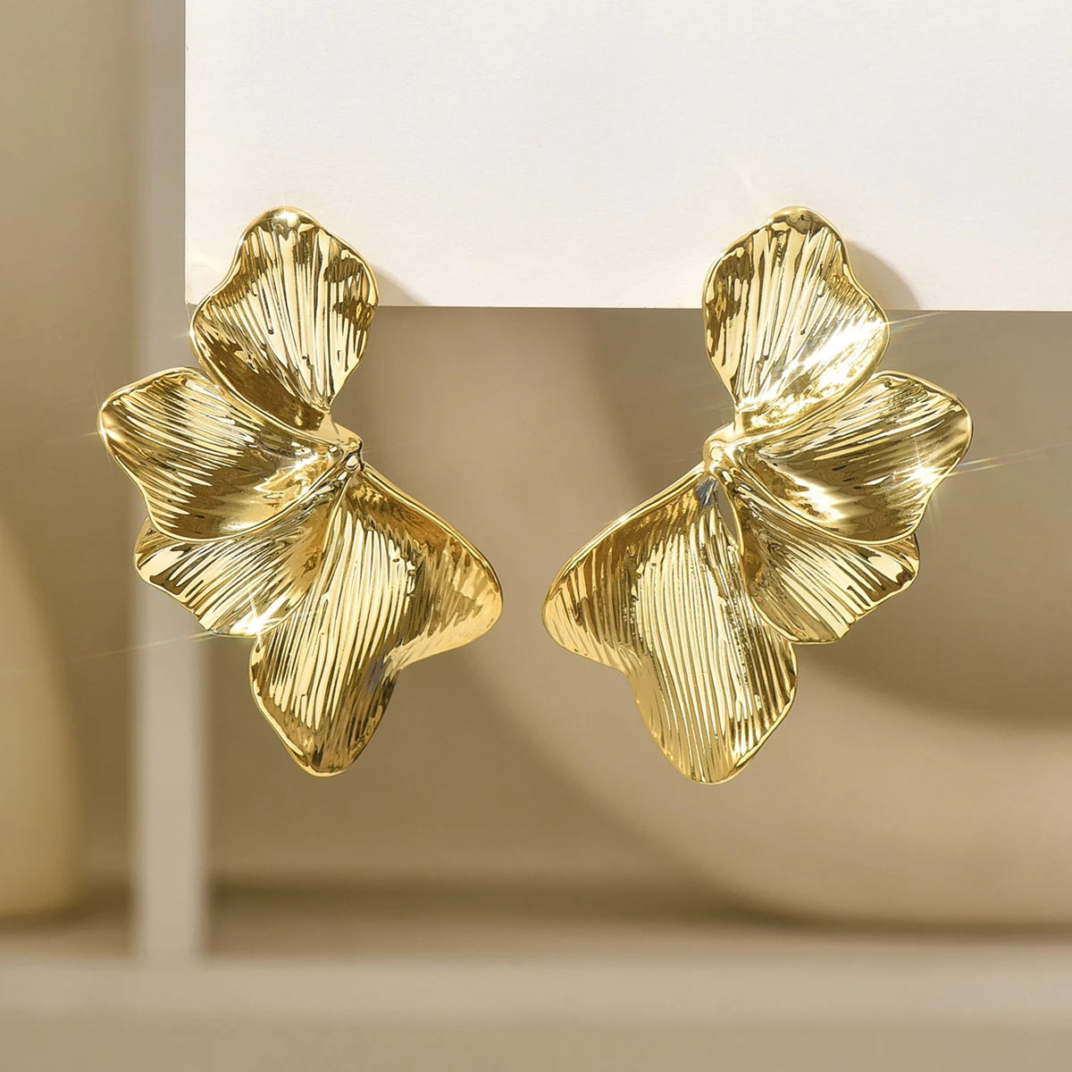 Örhängen dam – ginkgo blad studs i guldton